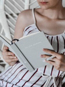 woman reading a light grey book